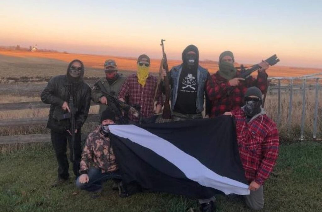 Jeremy Mackenzie, crouching left, poses with other Diagolon members during a 2021 "shooting party" in rural Saskatchewan. (Submitted to CBC)